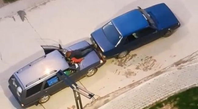 Kaputa oturup ayaklarıyla bozulan aracını itti